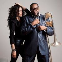 a man and woman standing next to each other in front of a large metal instrument