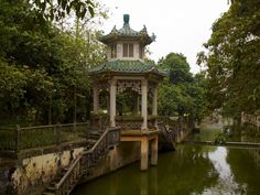 a gazebo in the middle of a river surrounded by trees