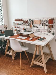 a white desk with two chairs next to it and shelves on the wall behind it