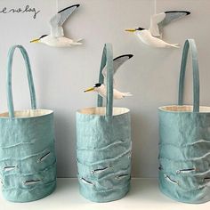 three bags with seagulls flying over them on the wall next to each other