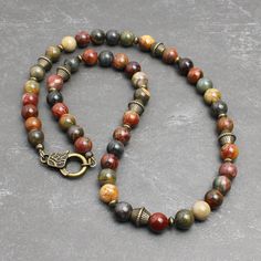 "* Made with Red Creek Jasper 8mm round beads, which has the earthy multi-colors of tan, olive green, burnt red, charcoal gray, and more. The softly muted colors of this natural stone makes it great for both men and women. * Embellished with antiqued brass finish pewter beads and brass spacers. It closes with an unique looking lobster clasp in antiqued brass finish pewter. * Strung with a professional quality durable wire, which is made of 49-strand fine stainless steel bundled and nylon coated. Bead Necklace For Men, White Choker, Necklaces Beaded, Red Creek Jasper, Earthy Jewelry, Necklace Layering, Natural Stone Jewelry, Summer Necklace, Funky Jewelry