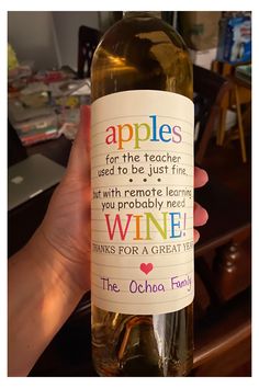 someone holding up a bottle of wine that says apples for the teacher used to be just fine