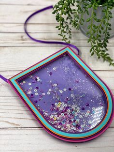 a purple and blue tray with sprinkles on it next to a potted plant