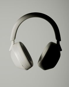 two white headphones hanging from the side of each other on a gray background with room for text