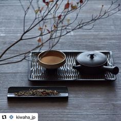 a tea tray with a cup and saucer on it next to a small plate