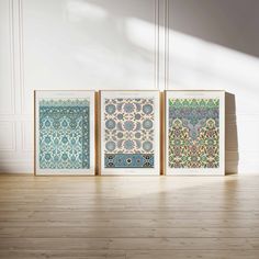 three framed art prints sitting on top of a wooden floor