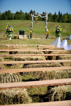 an outdoor ceremony with hay bales in the foreground