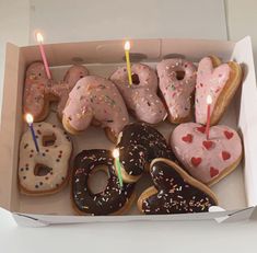 a box filled with lots of donuts covered in frosting and sprinkles