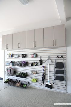 an organized garage with lots of storage and hanging items on the wall, including shoes