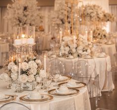 the table is set with white flowers and gold trimmings for an elegant wedding reception