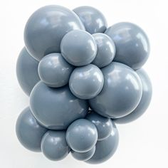 a bunch of gray balloons floating on top of each other in the shape of a cluster