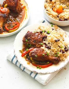 two plates with rice, meat and vegetables next to each other on a white table