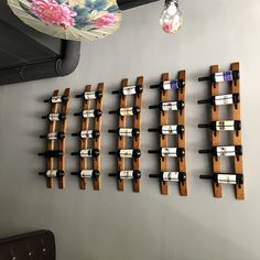 several wine bottles are lined up on the wall in front of a chandelier