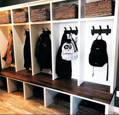 a bunch of coats are hanging on the wall next to some shelves with bags and purses