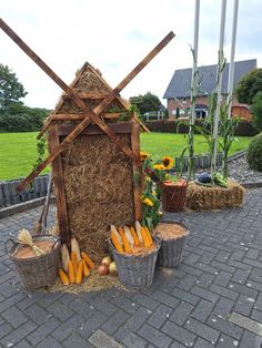 some baskets with carrots and corn in them on a brick walkway next to a house