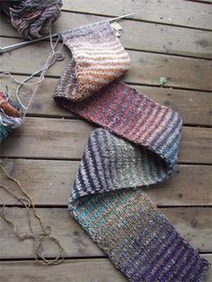 three knitted ties sitting on top of a wooden floor