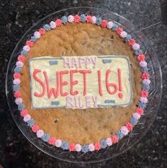 a happy sweet 16 birthday cake on a clear plate with red, white and blue icing