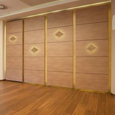 an empty room with wooden floors and decorative wall panels