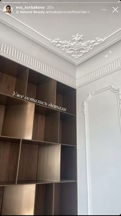 an open book shelf in the corner of a room with white walls and trimmings