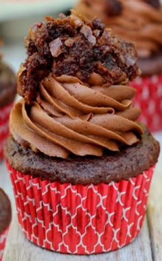 chocolate cupcakes with frosting on red paper wrappers