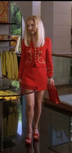 a woman in a red dress is walking through a store with her hand on her hip