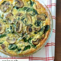 a quiche with mushrooms and spinach in a glass dish on a red and white checkered napkin