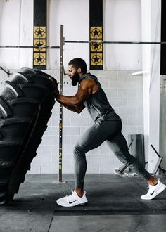 a man is working out with a tire