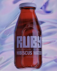 a bottle of rubi hibiscus water on a colorful background