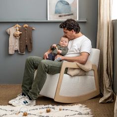 a man sitting in a chair holding a baby