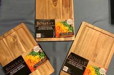 three wooden cutting boards sitting on top of a bed