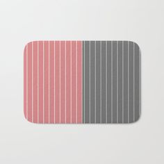 a gray and pink striped bath mat on a white background with the color red in it