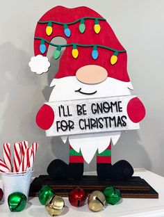 a sign that says i'll be gnome for christmas next to candy canes