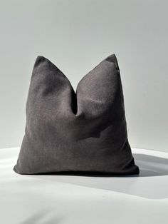 a gray pillow sitting on top of a white table