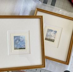 two framed pictures sitting on top of a table next to a ruler and pencils