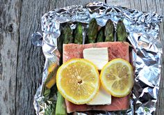 asparagus and lemon slices are arranged on tin foil