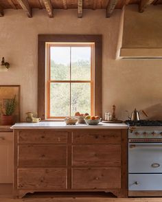 a kitchen with an old fashioned stove and wooden cabinetry in front of a window