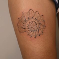 a woman's thigh with a black and white tattoo design on the side of her leg