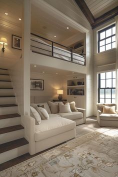 a living room filled with white furniture and lots of windows next to a stair case