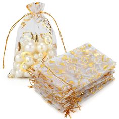 two bags filled with white and gold pearls