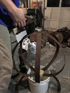 a man is using a circular metal object to work on something in a garage or workshop