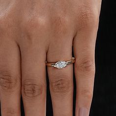 a woman's hand with a diamond ring on top of her finger, showing the middle finger