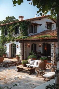 an outdoor living area with couches, tables and potted plants on the patio