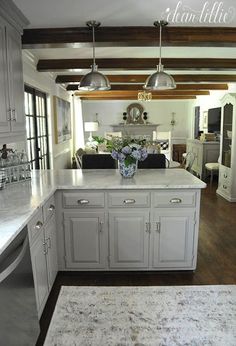 a large kitchen with white cabinets and marble counter tops, along with an island in the middle