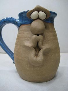 a ceramic mug with a monkey on it's face and hands in the shape of a heart