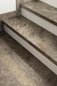 the stairs are made of marble and have gold designs on them