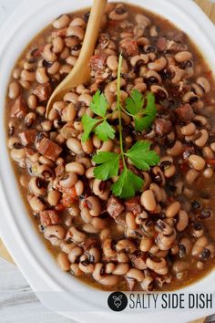 a white bowl filled with black - eyed beans and garnished with parsley