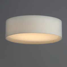 a white light hanging from the ceiling in a room with gray walls and flooring