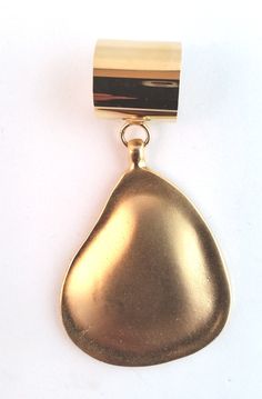 a gold pendant with a black and white stripe hanging from it's side on a white background