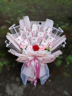 a bouquet made out of cards and ribbons with a rose on it's center