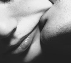 two people kissing each other in black and white